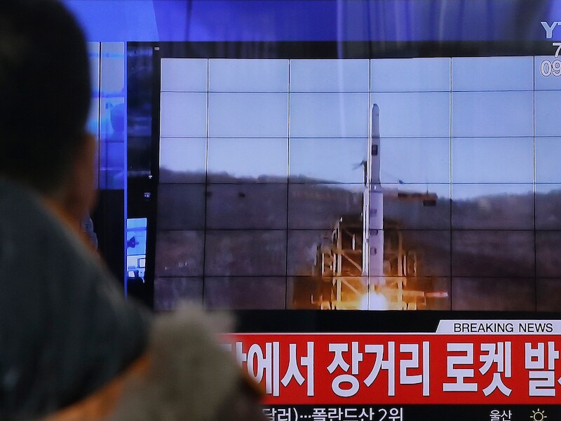 Een Zuid-Koreaan kijkt naar de lancering van een raket van buurland Noord-Korea.