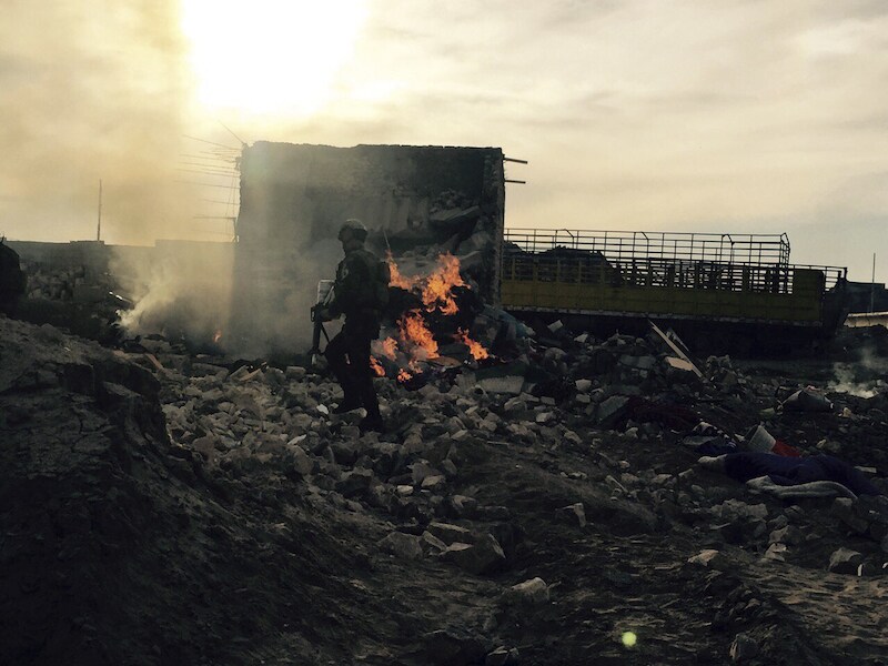 Een Iraakse soldaat loopt door het platgebombardeerde centrum van Ramadi.