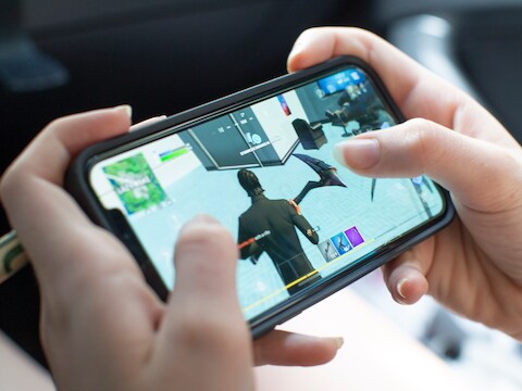 Een tienermeisje speelt het populaire Fortnite op haar iPhone.