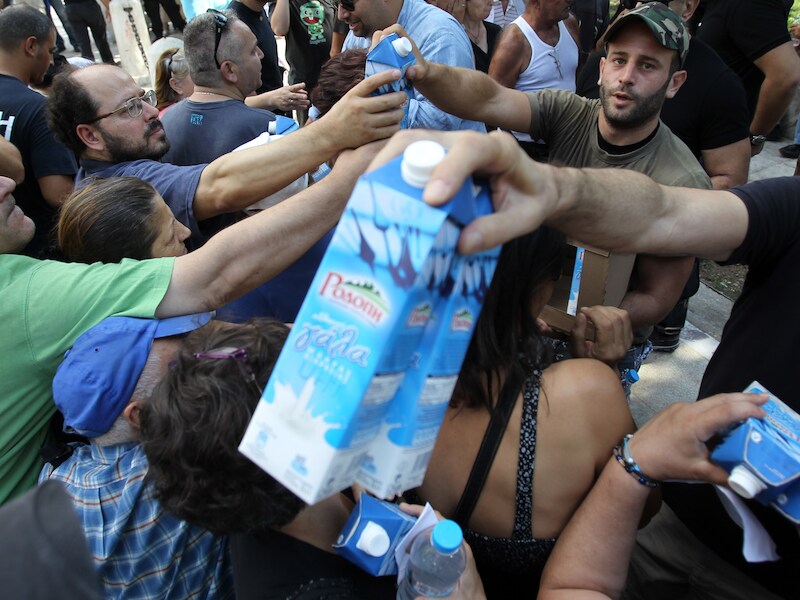 Leden van de Griekse neonazipartij 'Gouden Dageraad' delen melk uit in Athene. De militanten delen enkel voedsel uit aan autochtone Grieken.