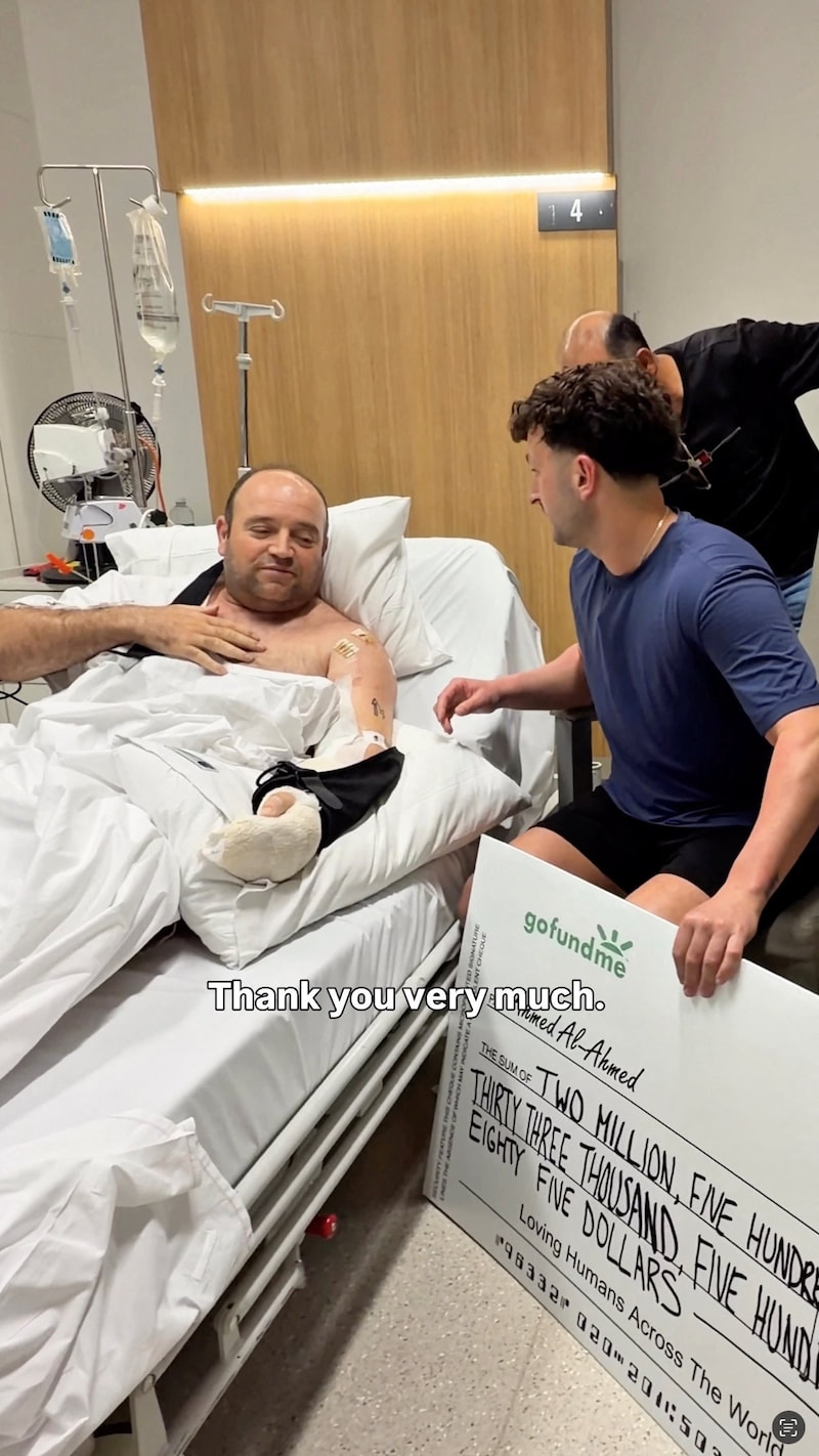 Influencer Zachery Dereniowski schenkt de cheque aan Ahmed al Ahmed, die nog herstelt in het ziekenhuis in Sydney