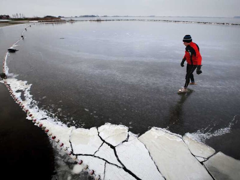 Schaatsfanaat Jacob Brandsma kijkt op het Slotermeer in Friesland of er al geschaatst kan worden op de Elfstedenroute bij de monding van de Luts.