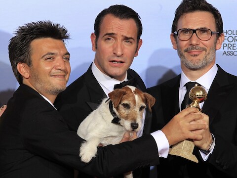 Producer Thomas Langmann (L), acteurJean Dujardin (C), regisseur Michel Hazanavicius én de hond Uggie poseren met hun Golden Globe.