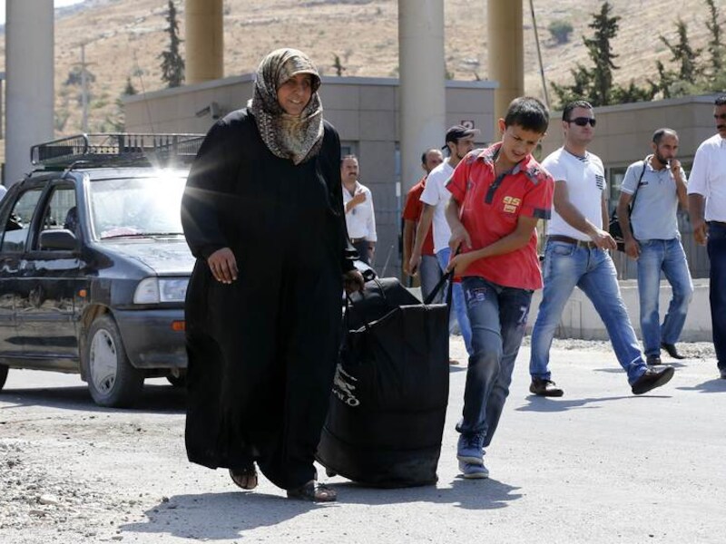 Syrische vluchtelingen steken de Turkse grens over.