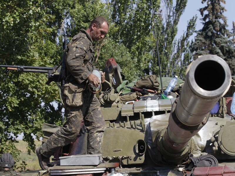 Een Oekraïense militair staat op een tank in de buurt van Marioepol.