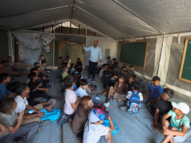 Palestijnse leerlingen volgen de eerste schooldag van het nieuwe schooljaar in een tentklaslokaal op een school in Khan Younis, in het zuiden van de Gazastrook. 