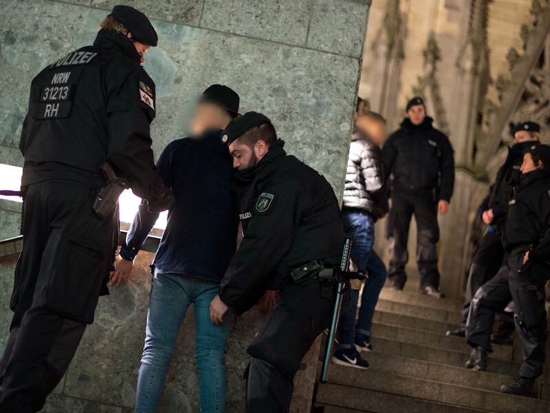 Agenten fouilleren een verdacht persoon bij het station van Keulen.