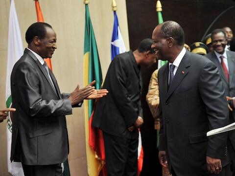 Blaise Compaore, president van Burkina Faso, heeft een beleefdheidsapplausje over voor Alassane Ouattara, president van Ivoorkust., na de ontmoeting van Ecowas.