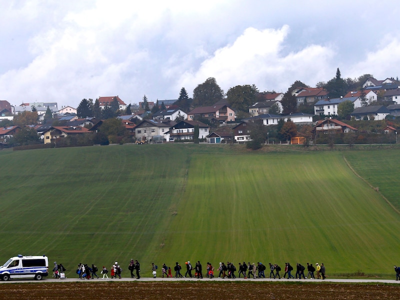 De Duitse politie escorteert migranten naar een registratiecentrum nadat ze de Oostenrijks-Duitse grens hebben overgestoken in Wegscheid, nabij Passau.