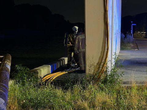Brandweermannen bij de glasvezelkabels die vuur vatten.