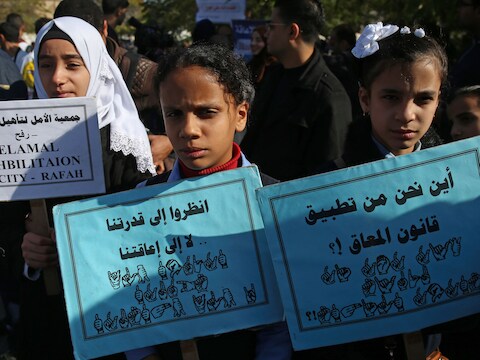 Palestijnse kinderen met een handicap houden bordjes omhoog in Gaza City waarbij ze rechten eisen voor mensen met een handicap.