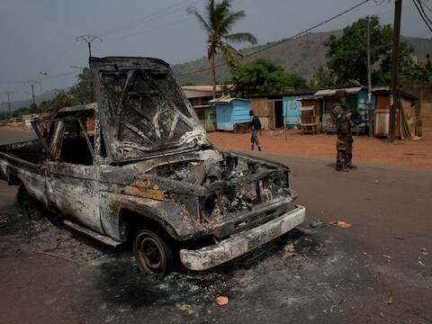 Franse militairen bij een uitgebrande pick-upauto in Bangui.