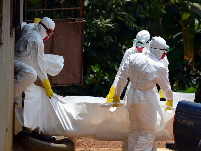 Het lichaam van een 18 maanden oude baby wordt weggedragen door medewerkers van het Rode Kruis in Liberia. Het kind stierf door ebola.