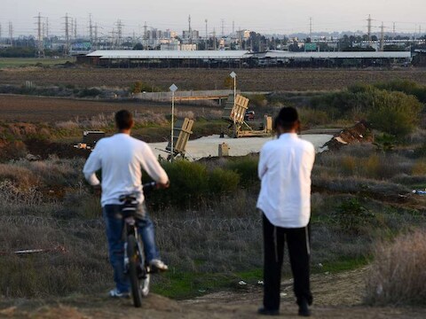 Twee Israëli's kijken vanop een heuvel naar de Iron Dome, het peperduur antiraketsysteem.
