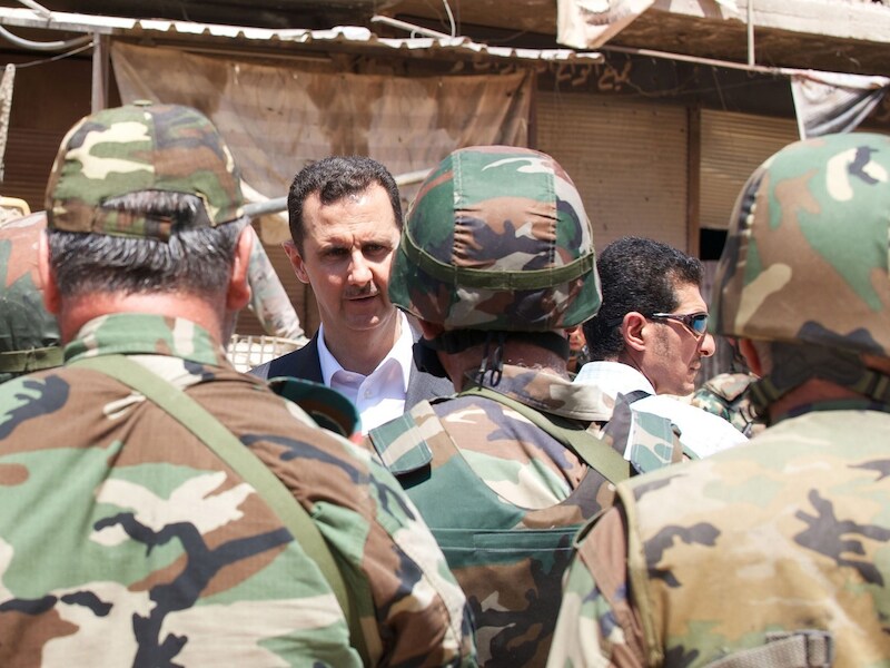 De Syrische president Bashar al-Assad tussen enkele Syrische militairen
