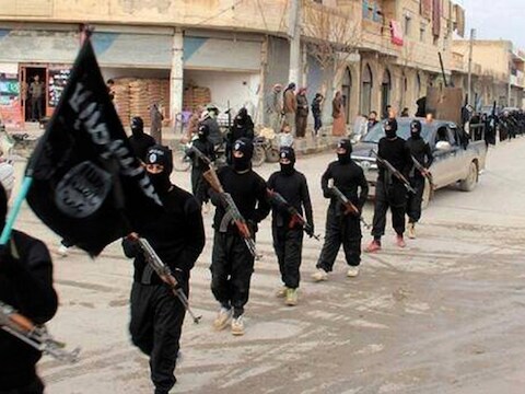 Strijders van de Islamitische Staat marcheren door de Syrische stad Raqqa.