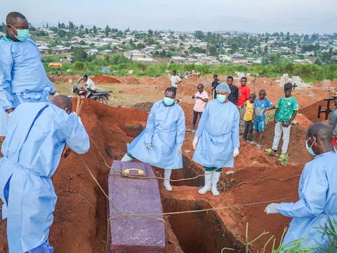 Beeld van 18 augustus. Hulpverleners in beschermende kleding bereiden zich voor om de kist met de stoffelijke resten van de 6-jarige Baudjo Baraka Jules, die aan ebola overleed, in een graf te laten zakken in Bunia, in het oosten van Congo.
