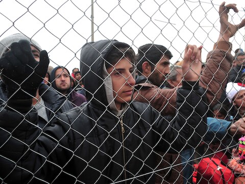 Vluchtelingen staan aan de grens bij Idomeni.