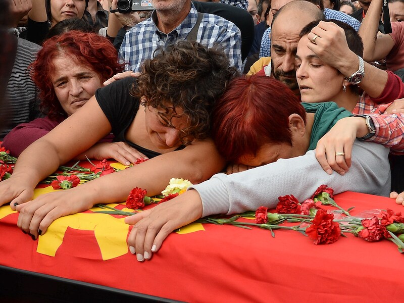 Familieleden van een van de slachtoffers rouwen bij zijn kust tijdens een begrafenisceremonie gisteren in Ankara. Duizenden demonstranten gaven de regering van president Erdogan de schuld van de bomaanslagen.