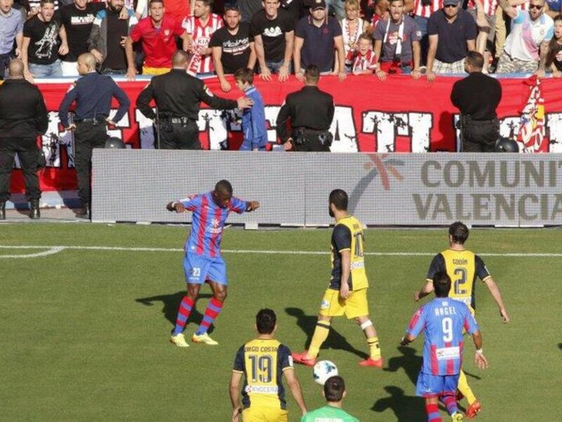 Linksboven doet een aanhanger van Atlético een aap na.