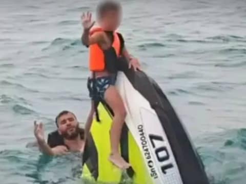 De jongste zoon was op de neus van de jetski geklommen.