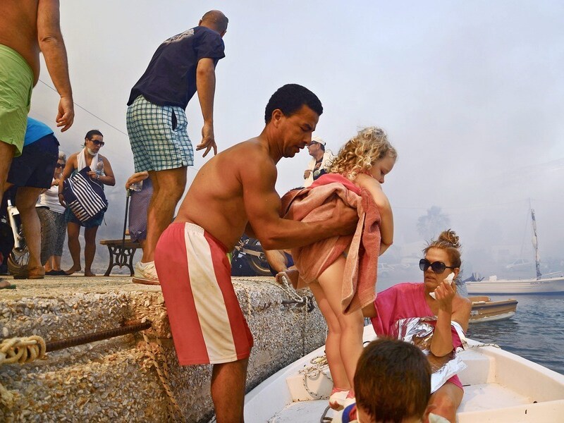 Toeristen en inwoners vluchte op het eiland Serifos, waar een bosbrand het plaatste Megalo Livadi naderde.
