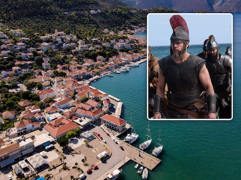 Boten liggen aangemeerd in de baai van het dorp Vathy op het Griekse eiland Ithaka. Inzet: Matt Damon als Odysseus in ‘The Odyssey’. 