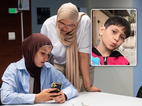 Shahd Alsafadi toont HLN-journaliste Ghadija Akouk de foto’s en medische verslagen van haar zwaargewonde neefje Omar (inzetfoto).