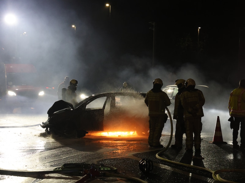 Brandweermannen blussen het brandende voertuig in de Geraardsbergsestraat in Aalst.