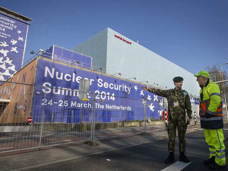 Een soldaat en een verkeersregelaar bij het gebouw van het World Forum, waar binnenkort de nucleaire top plaatsvindt.