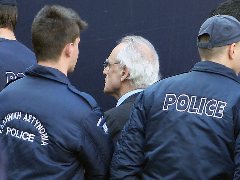 Tsochatzopoulos begeleid door agenten aan het gerechtsgebouw in Athene.