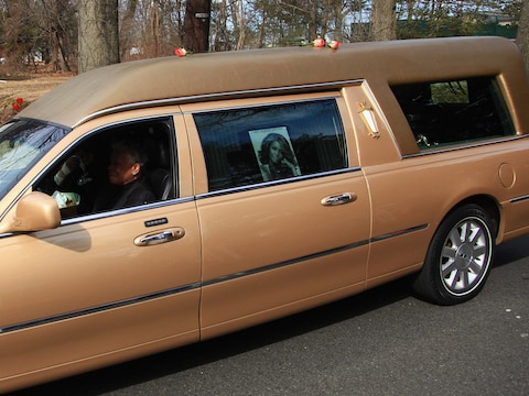 De kist werd vervoerd in een goudkleurige lijkwagen.