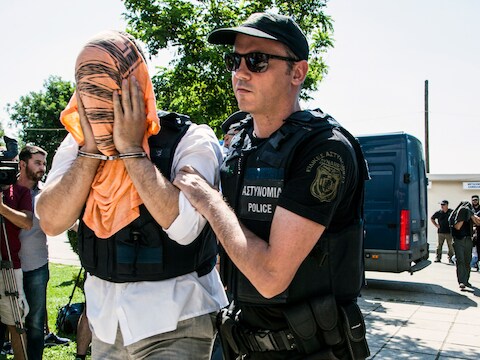 Een Turkse officier wordt op 21 juli naar de rechtbank in Alexandroupolis, in het noorden van Griekenland, overgebracht.