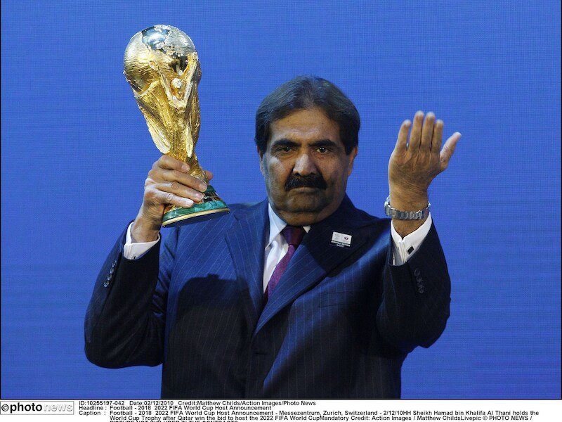 De emir van Qatar, Hamad bin Khalifa al-Thani, houdt de beker voor het WK voetbal 2022 vast.