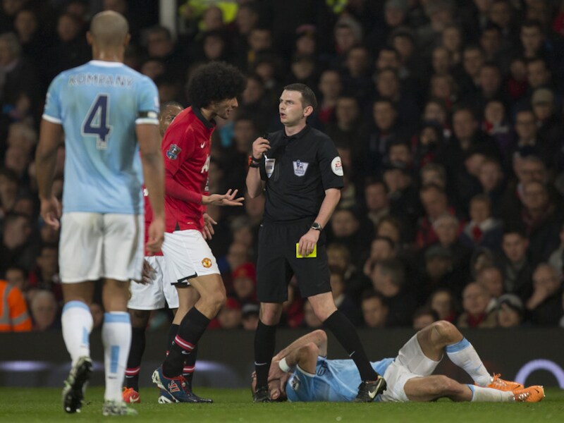 Fellaini heeft Zabaleta geveld en mag blij zijn dat Oliver het bij geel houdt. Kompany kijkt toe.
