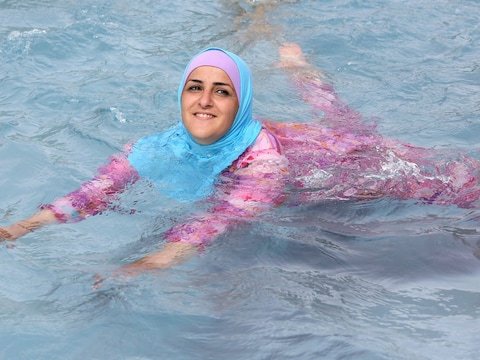 Illustratiebeeld. Een vrouw met een boerkini zwemt in het water.
