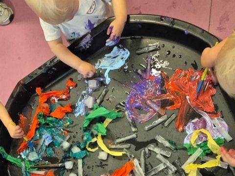 Peuters in kinderdagverblijf Tierlantuin schilderen met kleurrijke ijsstaafjes tijdens de warme dagen.  