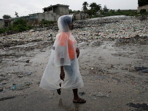 Een vrouw loopt langs een rivier in Port-au-Prince.