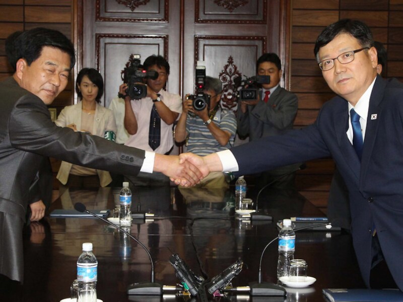 Suh Ho van Zuid-Korea schudt handjes met Park Chol-Su van Noord-Korea.
