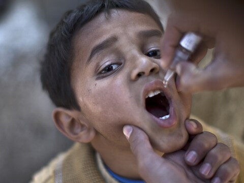 Een kind uit Pakistan krijgt een oraal vaccin tegen polio toegediend (archiefbeeld).