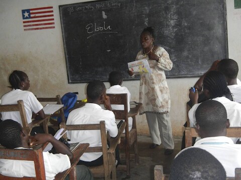 Een leerkracht in Liberia spreekt met studenten over het ebolavirus.