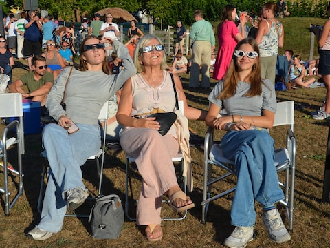 Heel wat mensen bekijken de zonsverduistering in het park van Meerbeke (Ninove), aan het Gemeenteplein, zoals Ann Van der Perren met haar kleindochters.