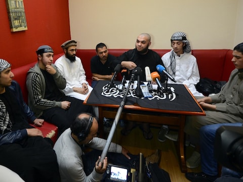 Abu Mujahid (midden) van Sharia4Belgium tijdens de geïmproviseerde persconferentie van vanavond.