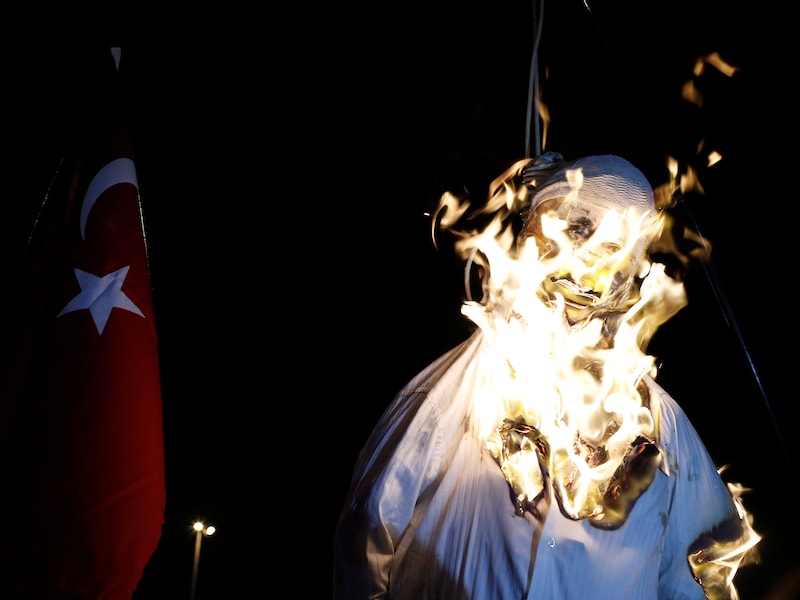 Aanhangers van de Turkse president Erdogan verbranden een pop met de beeltenis van Fethullah Gulen, die aan een strop hangt.