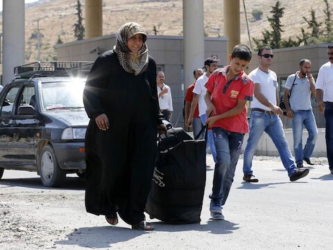 Syrische vluchtelingen steken de Turkse grens over.