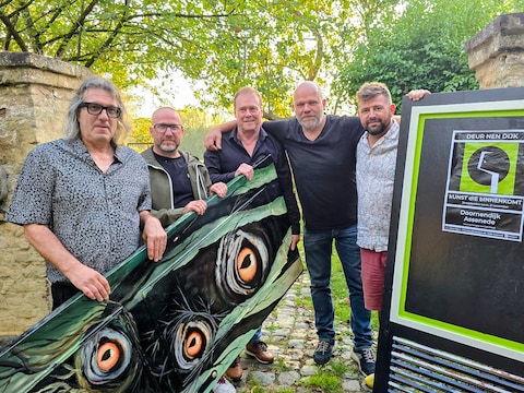 Het team van 'Deur Nen Dijk' toont een eerste beschilderde deur. Rechts zie je de deuren die nu al als promostunt overal in Assenede verschijnen.