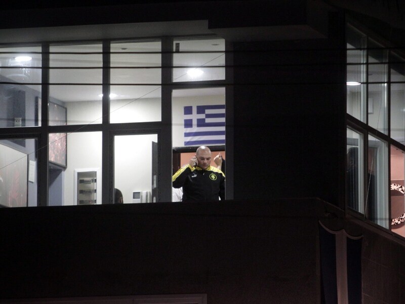 Parlementslid Giorgos Germenis van Gouden Dageraad telefoneert vanuit het lokaal waar de schietpartij gebeurde.