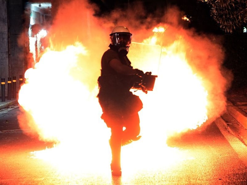 Een molotovcocktail ontploft vlak bij een lid van de oproerpolitie, gisteren tijdens een protestmars in Athene naar aanleiding van de moord op de linkse rapper Pavlos Fyssas.