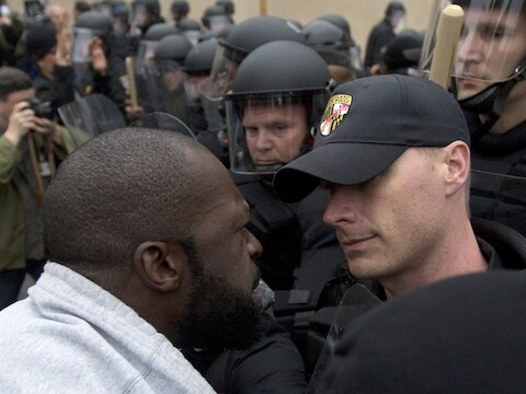 Een demonstrant schreeuwt tegen een politieagent tijdens een demonstratie in Baltimore, eind april