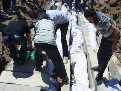 Syrische burgers aan het massagraf van meer dan honderd slachtoffers die in Houla geëxecuteerd werden.